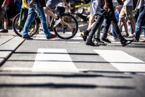 Many people and bicycles in a pedestrian crosswalk